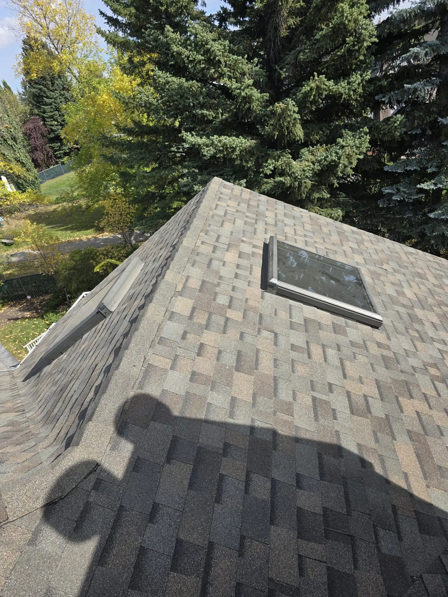 Impact-resistant curb-mount glass skylight installed on a shingle roof in Calgary, AB