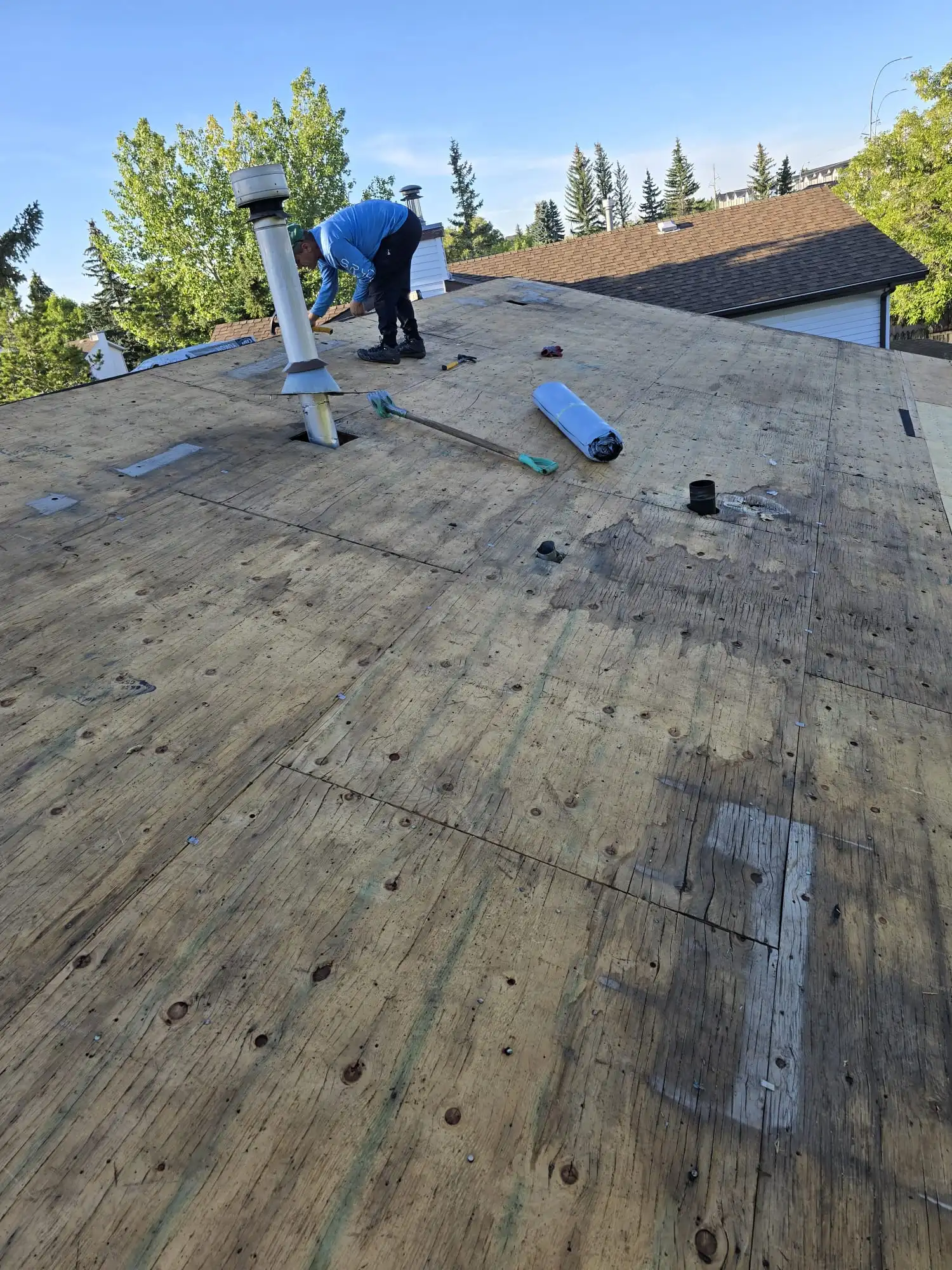 Owner of Apex Roofing Repair inspecting an exposed roof deck in Calgary